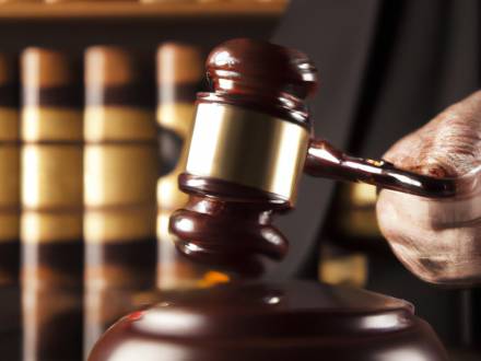 A close-up of a gavel being struck on a sound block